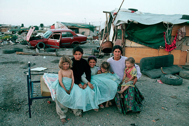 A Roma woman and her daughters sit on an old bed near dilapidated shacks and broken down cars. The Roma, or Gypsies, are travelling people and are often mistrusted by the societies in which they live. Gypsies are now concentraited in Southern Europe, though there are an estimated 9-12 Million Roma worldwide.   (Photo by Peter Turnley/Corbis/VCG via Getty Images)